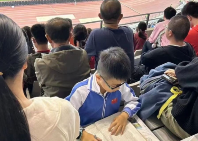 A number of elementary school students were spotted doing homework in the stands before the national soccer game